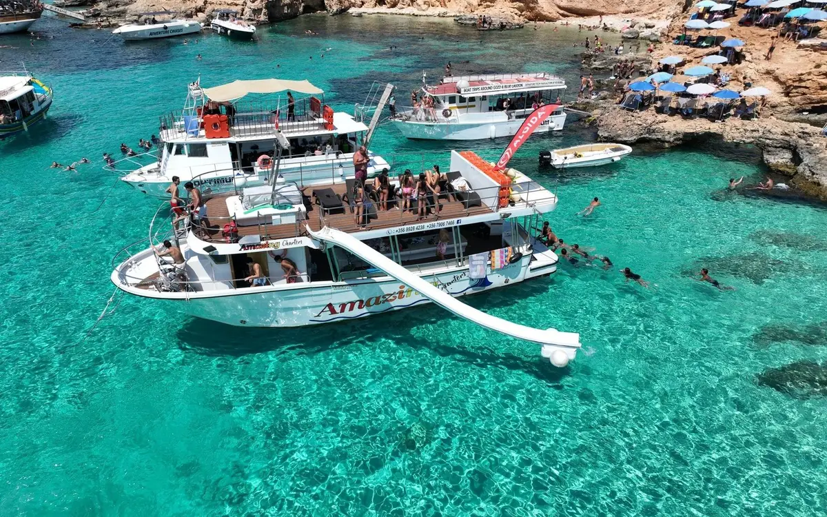 Tour boats moored side by side in the Blue Lagoon at Comino