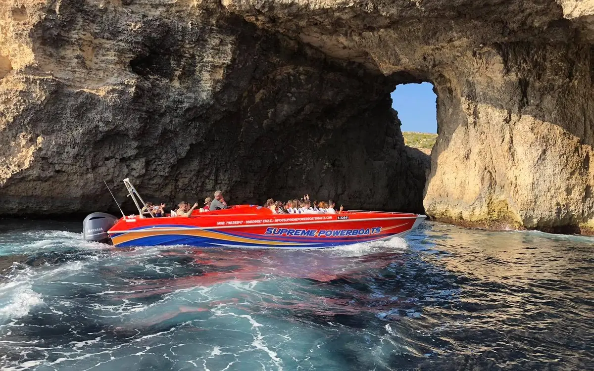 A boat entering a sea cave in the cliffs of Comino
