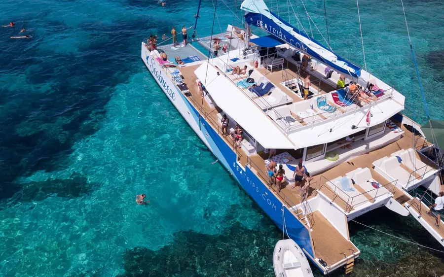 A catamaran anchored off Comino in clear water